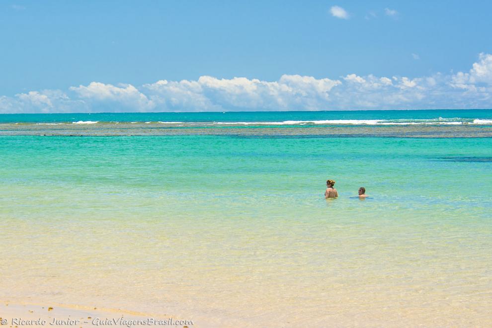 Imagem de duas pessoas aproveitando este mar maravilhoso da Praia Taipu de Fora.